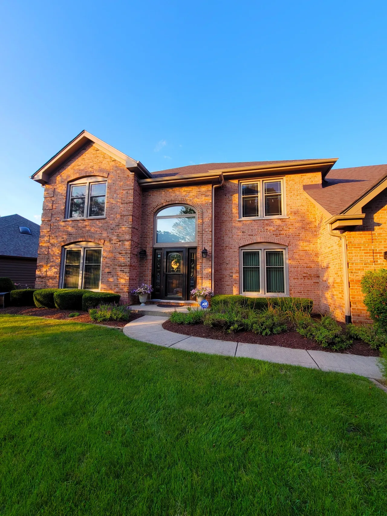 Brick home with landscape and curb appeal lighting at evening — St. Charles IL