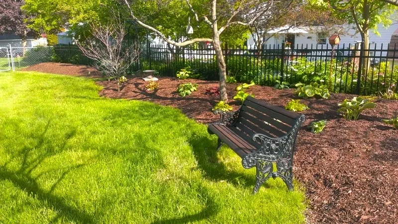 Park bench with manicured lawn and mulch landscape bed — Warrenville IL